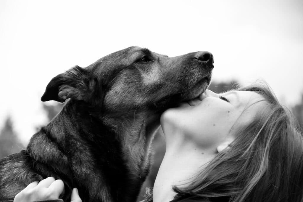 A Young Woman Hugging and Kissing Dog